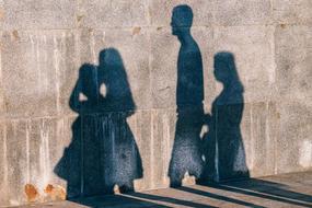 Silhouette of the people, on the wall, on the street of the city, in light