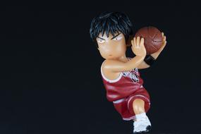 Cute figure of the basketball player, with the ball, at black background