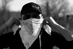 photo of a biker with a white scarf on his face