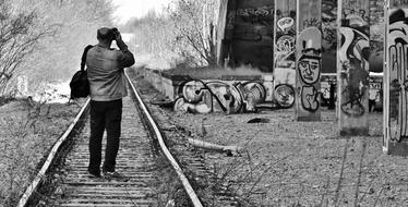 monochrome image of a photographer taking pictures of an abandoned railway station