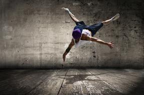 Young Street Dancer, boy in jump at grunge background