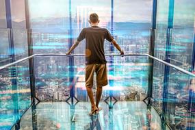 young man in a transparent elevator of a skyscraper in New York