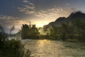 Beautiful and colorful landscape of the river, among the trees, near the mountains, in Vietnam, at colorful and beautiful sunset