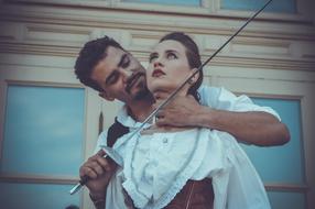a man threatens a girl with a sword