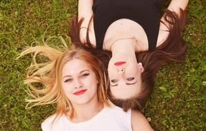 Blonde and Brown Hair Girls lie on grass