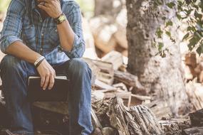 man Sitting with closed book in hand outdoor