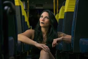young Woman sitting on floor between rows of seats in bus