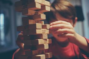 boy near playing with Jenga game