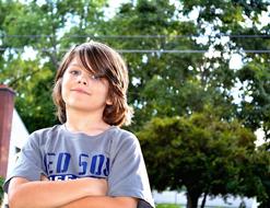 portrait of a boy against a background of green trees