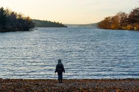 child Boy stands on waterside