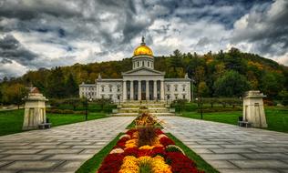 Beautiful State Capitol with the colorful flowers and green meadows in the garden, in Montpelier, Vermont, New England, America, under the cloudy sky