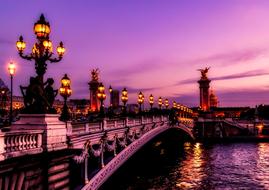 night photo of the bridge against the purple sky in Paris