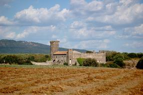 harvested field near aged Castle, italy