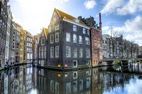 old buildings mirroring on water at winter, netherlands, amsterdam