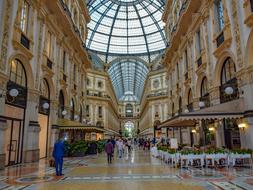 tourists walk in the Galleria Vittorio Emanuele II in Milan