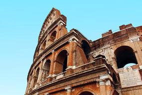 Beautiful Colosseum with arches, at blue sky on background, in Rome, Italy