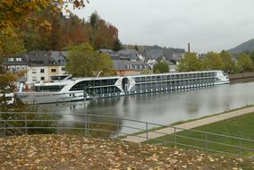 Cruise Ship at riverside in front of town, germany, saarburg on the background with the buildings and plants