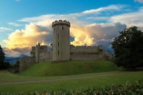 Beautiful landscape of the Warwick Castle, on the green hill, at colorful and beautiful sky with clouds, in Warwick, England, UK