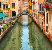 open air cafe on picturesque alley at bridge across channel, Italy, Venice