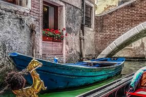 Beautiful turquoise gondola on the green canal, near the bridge, in Venice, Italy