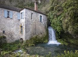 waterfall near the stone building