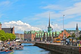 Beautiful landscape of Copenhagen with the water channel, among the colorful houses in Denmark, under the blue sky, with clouds