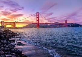 Golden Gate Suspension Bridge above water at scenic colorful sunset, usa, california