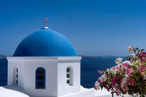 flowers and Blue Dome of white church at sea and sky, greece, Santorini