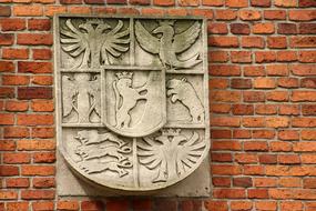 stone coat of arms on a brick wall