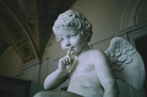 Beautiful, white sculpture of the angel boy with wings