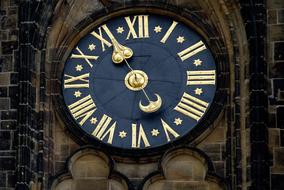 gold numbers and arrows on a tower clock