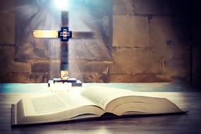 Beautiful, open Holy Bible and shiny cross in the church