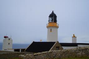 Lighthouse at Dunnet Head Peninsula at cloudy sky background in Scotland