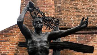 black statue near brick wall