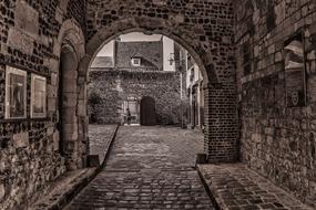 arched gateway in courtyard of aged stone building