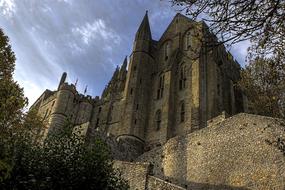 Beautiful landscape with the Mont St Michael, among the green trees, in France