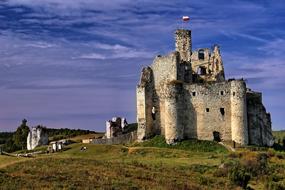 ruined medieval MirÃ³w Castle with flag on tower, poland