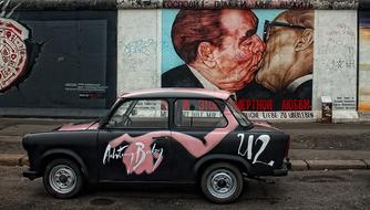 vintage car at graffiti on Berlin Wall East Side gallery, germany