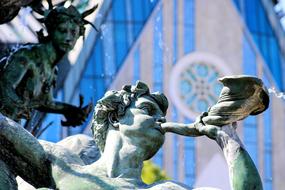 aged sculpture of the young boy plays horn in germany, Leipzig