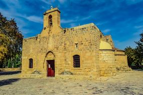 Beautiful Panagia Angeloktisti among the colorful trees at blue sky with white clouds in Kiti, Cyprus, Greece