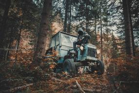 man in Mask on old Tractor in forest