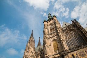 Beautiful and decorated castle at blue sky with white clouds on background, in Prague, Czech Republic