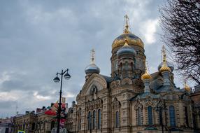 Beautiful Optina church with gold domes in Russia under cloudy sky