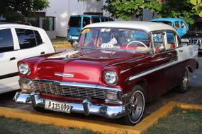 burgundy retro car in a parking lot in Cuba