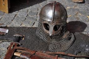 medieval helmet and weapons on the pavement