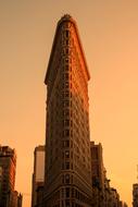 Flatiron building in New York, America, at colorful and beautiful, gradient sunset on background