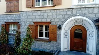 decorative wooden doors and shutters on an old building in the Alps