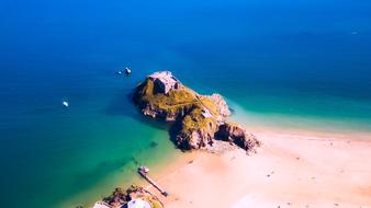 Beautiful fortress on the colorful hill, on the sandy beach in Tenby, Wales