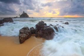 stones, ocean waves on the background of sunset