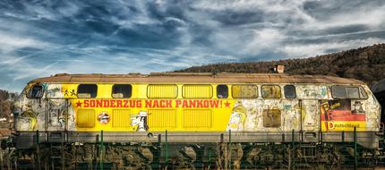 Colorful, old train, with the flag of Germany, in Pankow, Berlin, Germany, under the cloudy sky